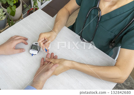 Shot of the female doctor in uniform measuring blood sugar level of the patient 132842680