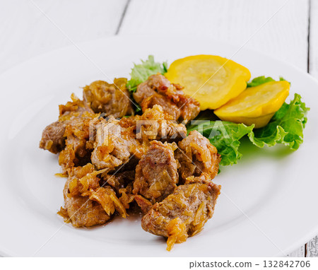 Delicious fried pork meat presenting on white plate with vegetable garnish 132842706