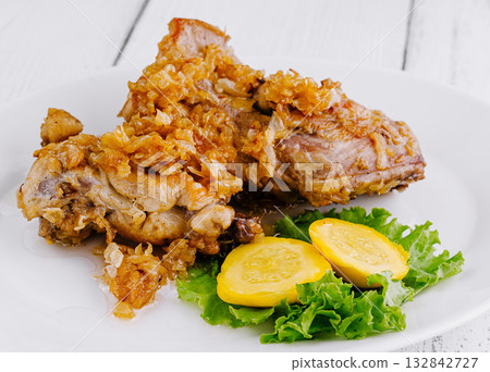 Crispy fried chicken legs lying on white plate with vegetable garnish Crispy fried chicken legs lying on white plate with vegetable garnish 132842727
