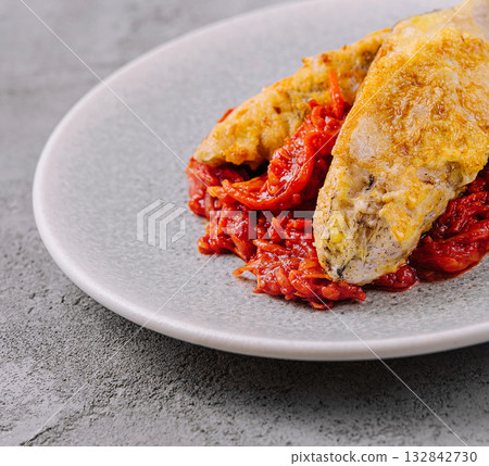 Grilled fish with sun-dried tomatoes on plate 132842730