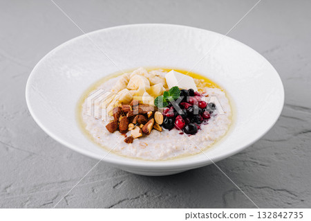 Oatmeal porridge with berries, banana and almonds for healthy breakfast Oatmeal porridge with berries, banana and almonds for healthy breakfast 132842735