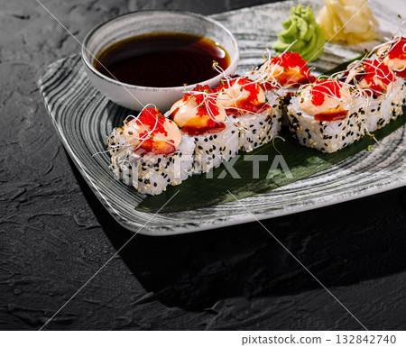 Gourmet sushi roll with toppings on slate background Gourmet sushi roll with toppings on slate background 132842740