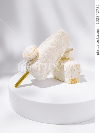 Delightful coconut ice cream treats on a simple white display Delightful coconut ice cream treats on a simple white display 132842783