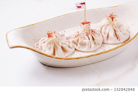 Delicious dumplings placed elegantly in a serving dish at a dining table Delicious dumplings placed elegantly in a serving dish at a dining table 132842848