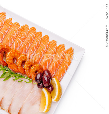 Seafood platter with salmon, shrimp, and lemon garnishes on table Seafood platter with salmon, shrimp, and lemon garnishes on table 132842853
