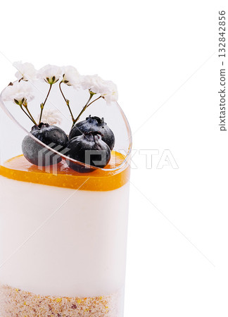 Delicious layered dessert with fruit and flowers in elegant presentation 132842856