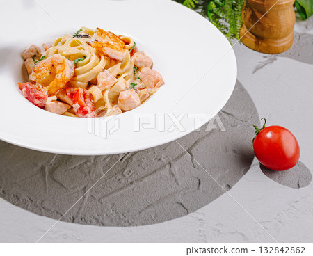 Delicious creamy fettuccine with shrimp and tomato on a stylish plate Delicious creamy fettuccine with shrimp and tomato on a stylish plate 132842862