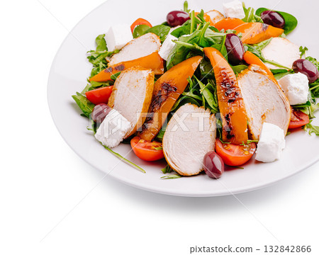 Grilled chicken and peach salad with feta cheese and olives on a plate 132842866