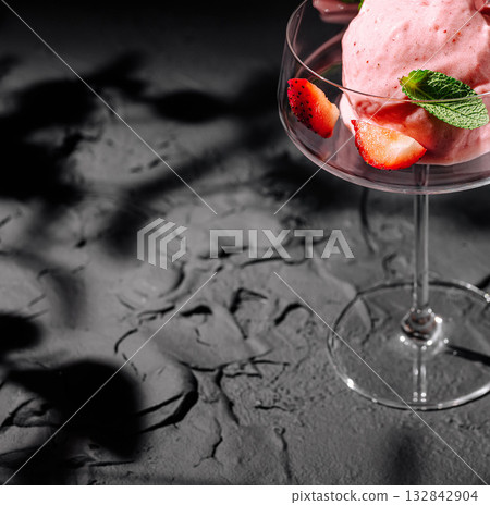 Refreshing strawberry dessert served in elegant glass on textured surface Refreshing strawberry dessert served in elegant glass on textured surface 132842904