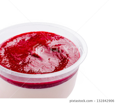 Creamy dessert topped with berry sauce in a clear cup on a white background Creamy dessert topped with berry sauce in a clear cup on a white background 132842906