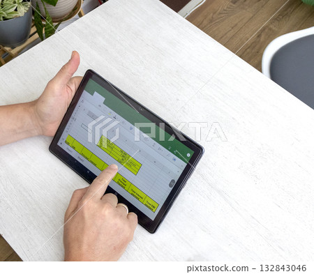Close up shot of the man using tablet, studying mortgage loan amortization table 132843046