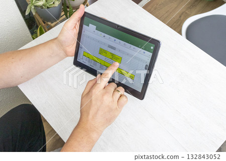Close up shot of the man using tablet, studying mortgage loan amortization table Close up shot of the man using tablet, studying mortgage loan amortization table 132843052