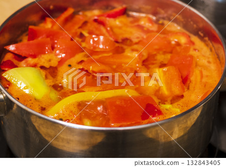Green and red capsicums, cut in large slices boiling in the pot 132843405