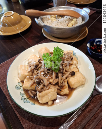Fried tofu with mushrooms and rice on a wooden table 132843638