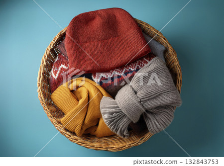 Knitted hats and sweaters in a basket 132843753