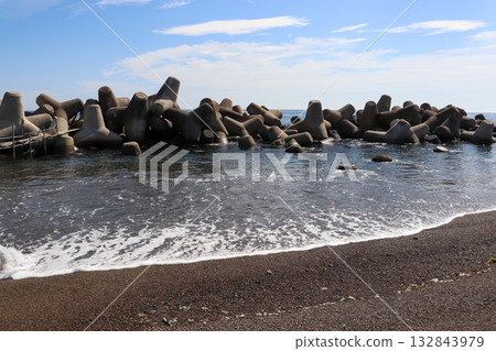 Tetrapods and the shoreline lined up under the blue sky Tetrapods and the shoreline lined up under the blue sky 132843979