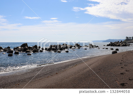 平靜的海景，白色的波浪輕拍海岸線，藍天白雲。 132844058