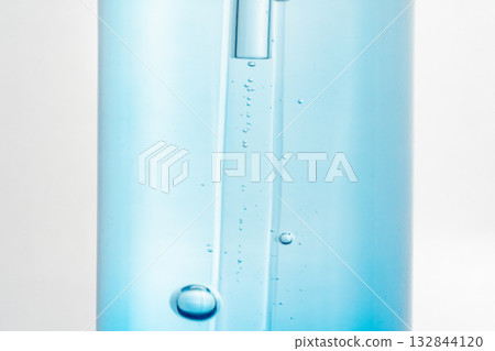 Blue glass bottle with a dropper containing air bubbles. Concept of cosmetic serum, skincare, transparency, minimalism, texture, product detail, laboratory-style beauty photography. Blue glass bottle with a dropper containing air bubbles. Concept of cosmetic serum, skincare, transparency, minimalism, texture, product detail, laboratory-style beauty photography. 132844120