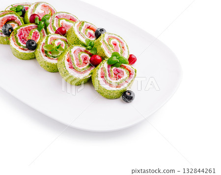Colorful vegetable rolls with cream cheese and berries on a white plate 132844261