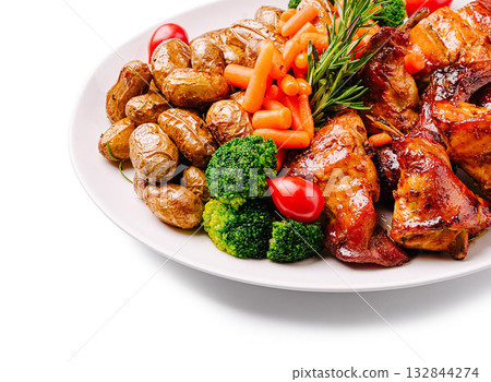 Grilled chicken with roasted potatoes and mixed vegetables served on a plate 132844274