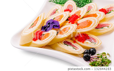 Colorful sushi rolls served elegantly on a white platter with garnishes 132844283