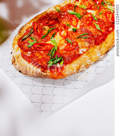 Delicious flatbread topped with spicy tomato sauce and fresh herbs 132844305