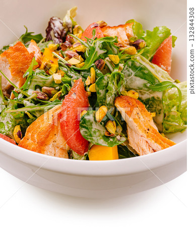 Fresh mixed salad with grilled chicken and roasted pistachios served in a bowl 132844308