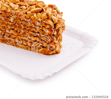 Crunchy peanut caramel treat displayed on a white tray with simple design 132844328