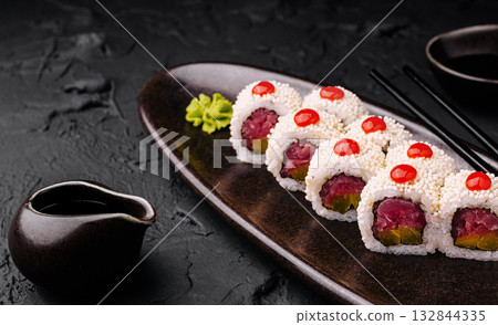 Sushi rolls with tuna and colorful toppings on a black plate Sushi rolls with tuna and colorful toppings on a black plate 132844335