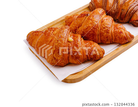 Freshly baked croissants arranged on a wooden tray ready for serving Freshly baked croissants arranged on a wooden tray ready for serving 132844336
