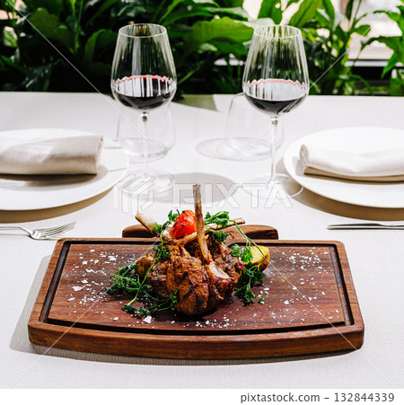 Fine dining experience with gourmet lamb dish and wine setting 132844339