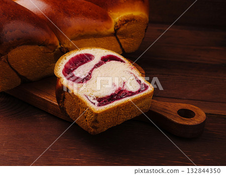 Freshly sliced sweet bread with berry filling on wooden board 132844350