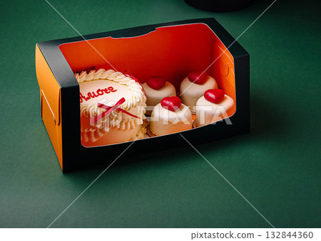 Delicious dessert box featuring cake and mini pastries with heart decorations Delicious dessert box featuring cake and mini pastries with heart decorations 132844360