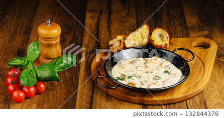 Delicious creamy mussels dish served with fresh herbs and bread 132844376
