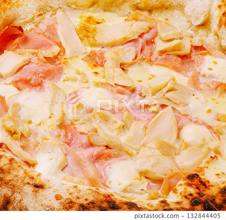 Delicious pizza topped with ham and artichokes served in a cozy pizzeria Delicious pizza topped with ham and artichokes served in a cozy pizzeria 132844405