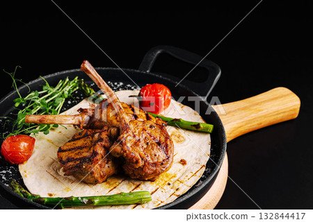 Grilled lamb chops served on a sizzling platter with fresh vegetables Grilled lamb chops served on a sizzling platter with fresh vegetables 132844417