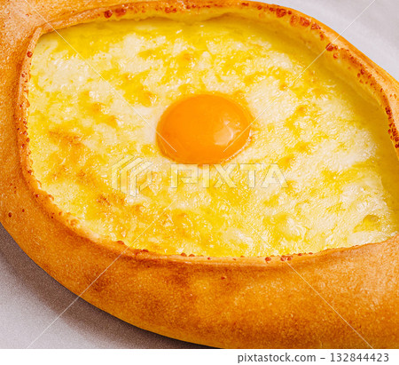Delicious cheese-filled khachapuri with an egg on top from a local bakery Delicious cheese-filled khachapuri with an egg on top from a local bakery 132844423