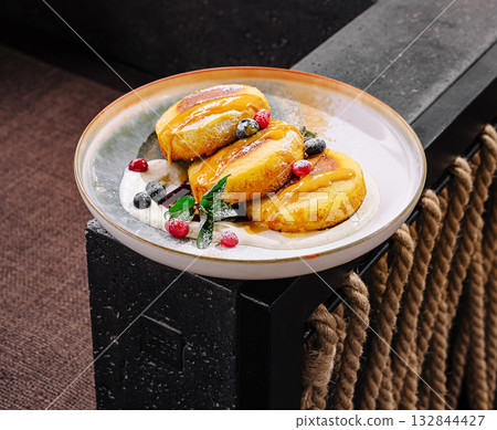 Delicious cottage cheese pancakes dessert served on a beautifully crafted plate in an elegant setting 132844427