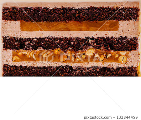 Decadent layers of chocolate dessert with caramel and nuts at a bakery Decadent layers of chocolate dessert with caramel and nuts at a bakery 132844459