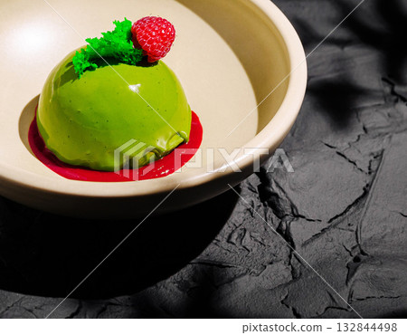 Delicious green dessert served on an elegant plate with fruit garnish Delicious green dessert served on an elegant plate with fruit garnish 132844498