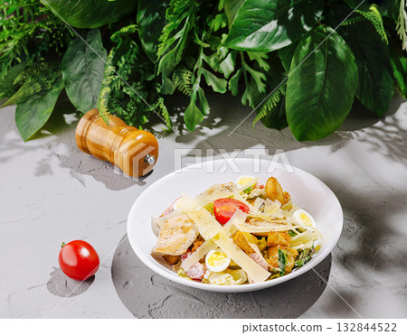 Colorful salad with vegetables and dressing presented on a table 132844522