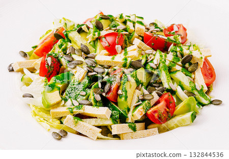 Fresh salad with tomatoes, avocado, and seeds drizzled with dressing Fresh salad with tomatoes, avocado, and seeds drizzled with dressing 132844536