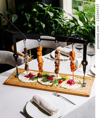 Exquisite kebab presentation at a gourmet restaurant with lush greenery 132844537