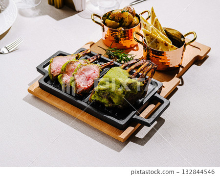 Delicious lamb chops served with sides in an elegant dining setting 132844546