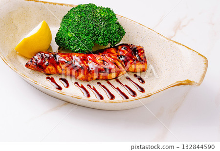 Grilled salmon fillet served with broccoli and lemon at a stylish restaurant Grilled salmon fillet served with broccoli and lemon at a stylish restaurant 132844590