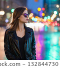 A young woman wearing sunglasses with a night view in the background 132844730