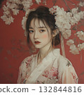 A young woman in a kimono stands in front of cherry blossoms 132844816