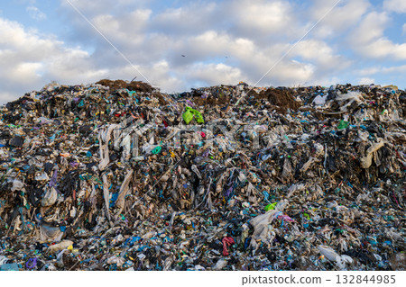 Garbage accumulates in a large landfill, showcasing pollution and ecological issues caused by plastic waste and debris in the environment 132844985