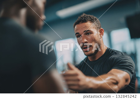 Personal trainer motivating athlete during workout in gym 132845242