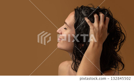 Woman massaging wet scalp with fingers during gentle hair washing Woman massaging wet scalp with fingers during gentle hair washing 132845502